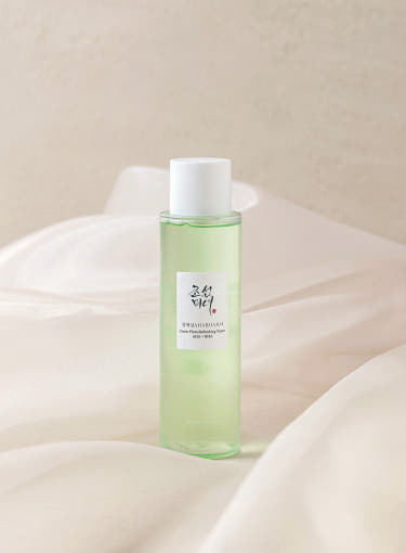 Beauty of Joseon Green Plum AHA BHA Toner 150ml bottle on soft fabric background, perfect for daily exfoliation.