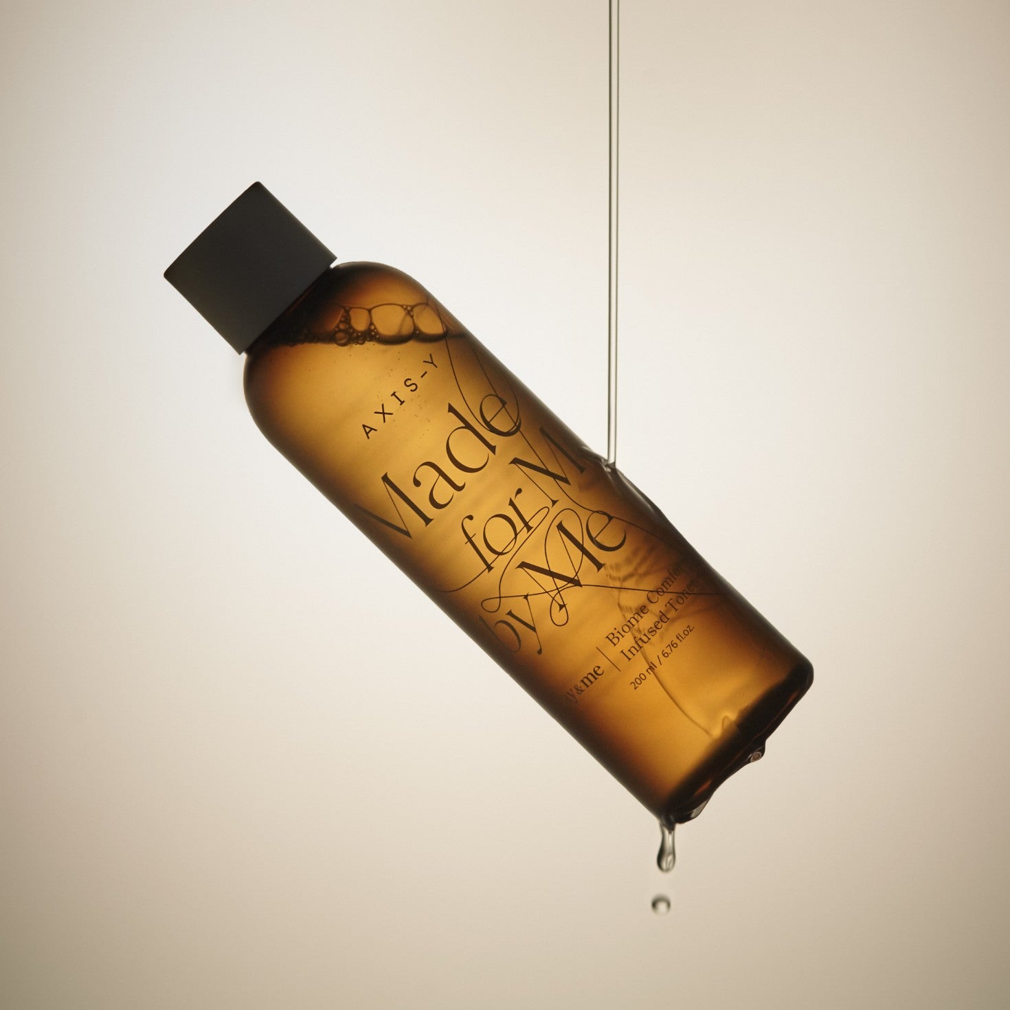 Amber bottle with 'Made for Me' text on a beige background