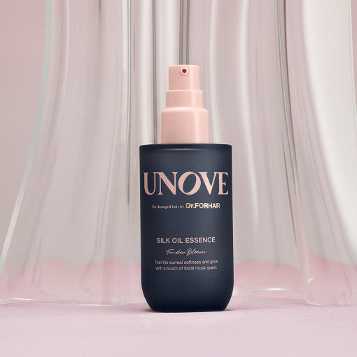 UNOVE Silk Oil Essence 70ml in clear beige-tinted pump bottle, glossy liquid inside, styled on a clean neutral surface