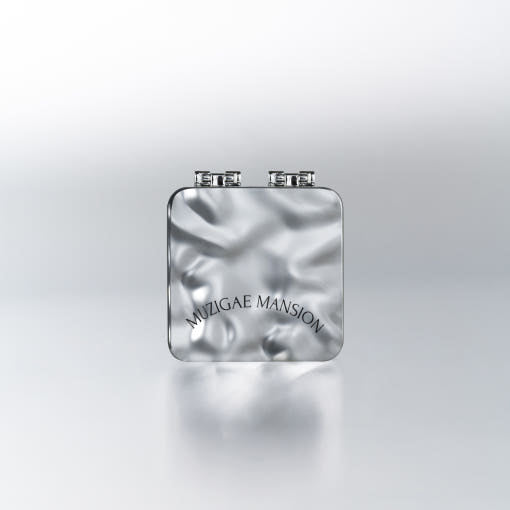 A compact with a built-in mirror and puff, labeled 'Muzigae Mansion', designed for facial blotting with oil paper sheets.