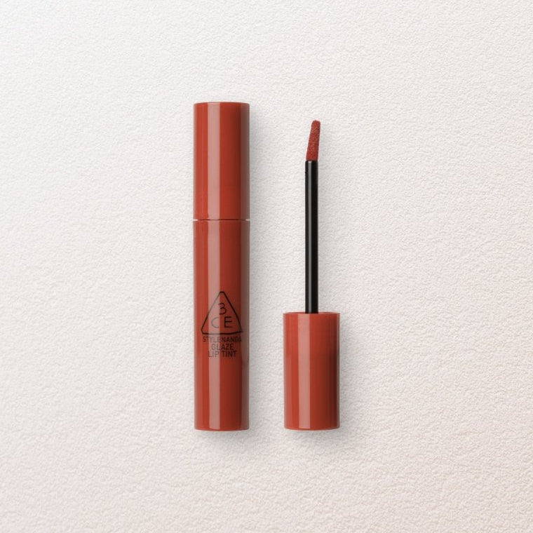 Lipstick with open cap on a light textured background
