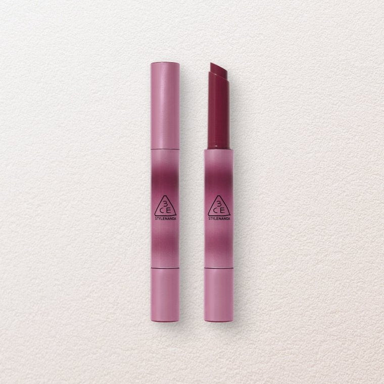 Two pink lipsticks with a brand logo on a light gray background