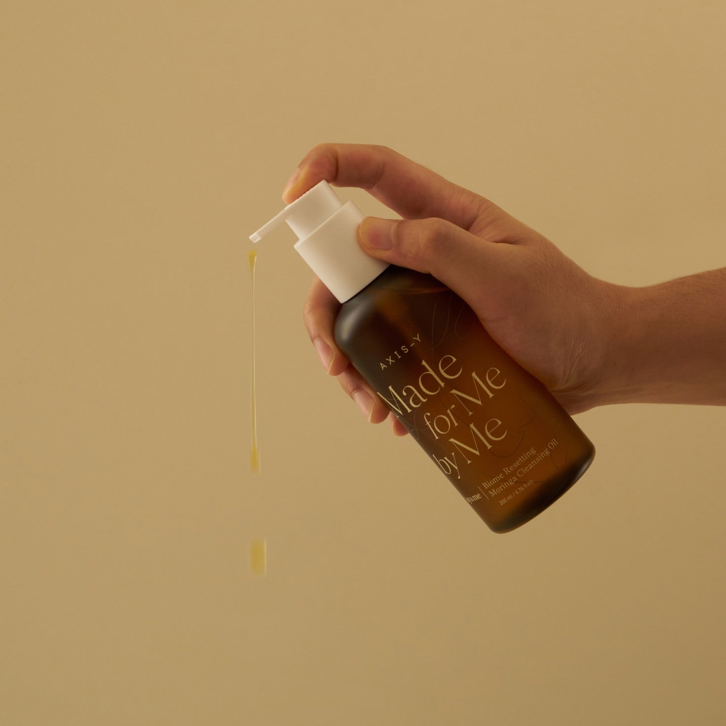 Hand holding a bottle labeled 'Made for Me' with a beige background