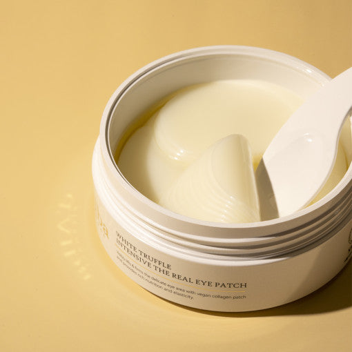 d'Alba White Truffle Eye Patch in gold-accented jar, shown with translucent hydrogel patches for under-eye care