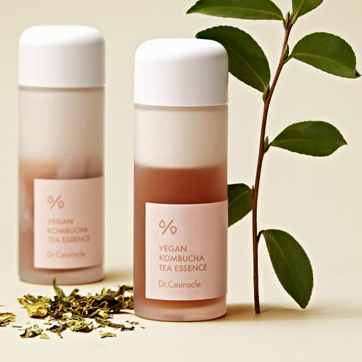 Dr.Ceuracle Vegan Kombucha Tea Essence bottles with botanical leaves and dried tea, ideal for all skin types.