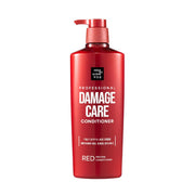 Red bottle of damage care conditioner on a white background